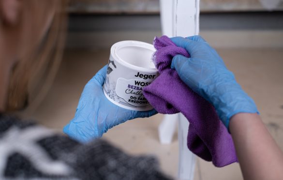 Za pomocą ściereczki z mikrofibry zaaplikuj warstwę bezbarwnego wosku, który zabezpieczy mebel.