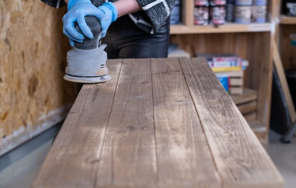 Aby odsłonić strukturę drewna na blacie konsoli, przeszlifuj go za pomocą szlifierki mimośrodowej i papieru ściernego o gradacji 120.